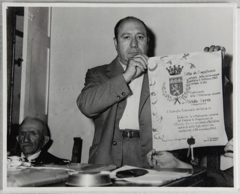 Poggibonsi, 18-19 luglio 1964, XX° anniversario della liberazione. Il sindaco Danilo Ghizzani mostra il documento di conferimento ad Alcide Cervi della cittadinanza onoraria.